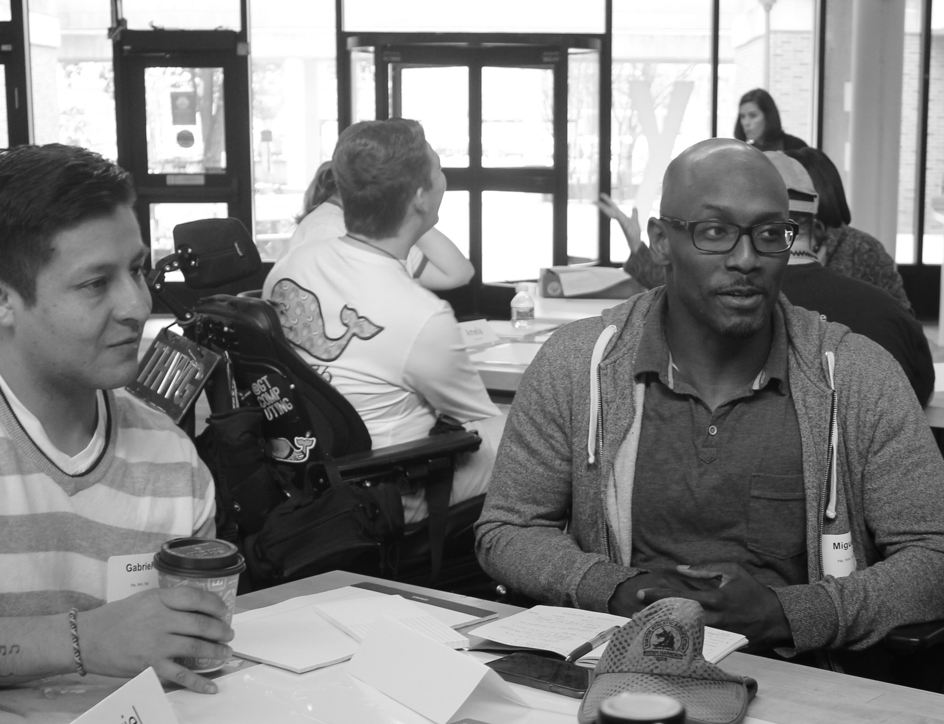 A diverse team collaborating on a design sprint with another team faded in the background.